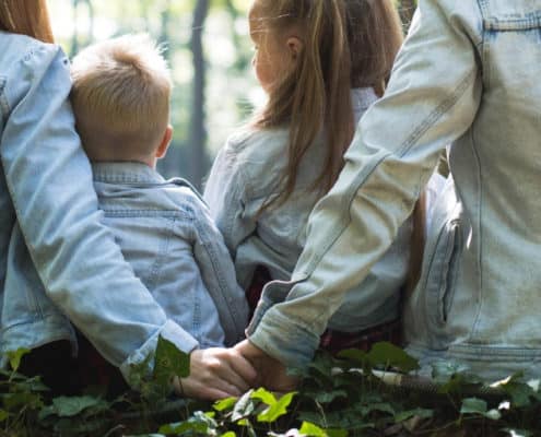 family in the woods, father and mother holding hands