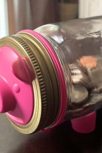 mason jar with money in it on its side, and piggy bank front and legs