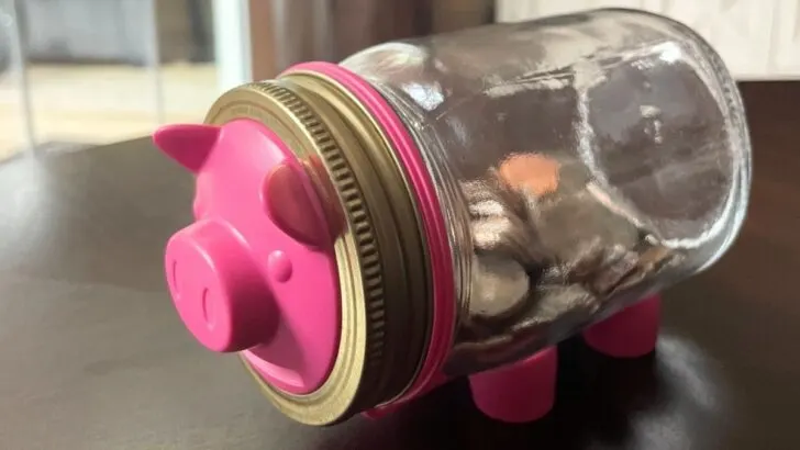 mason jar with money in it on its side, and piggy bank front and legs