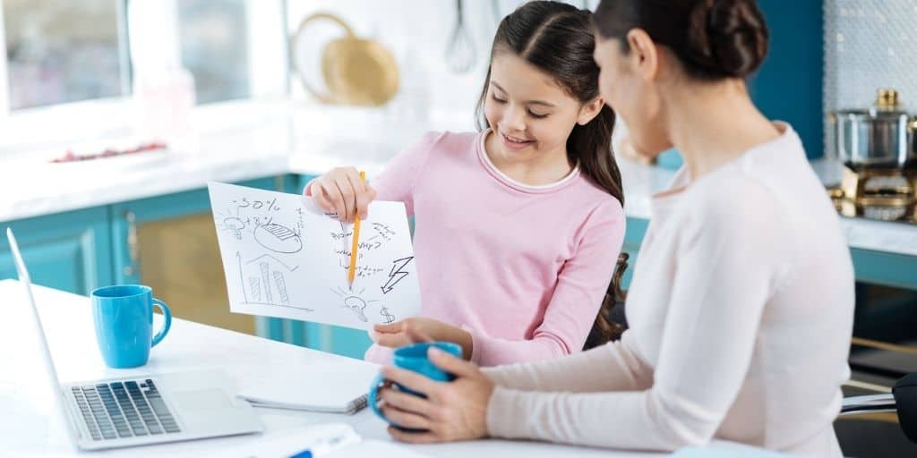 child with kid goal setting worksheet, pointing to it while showing to mother