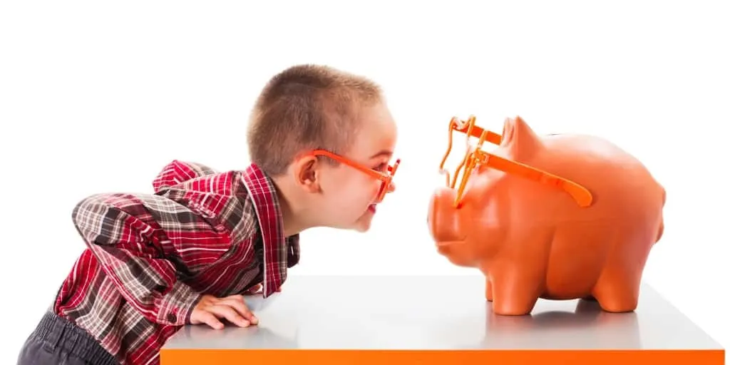 boy with orange glasses staring at an orange piggy bank with orange glasses