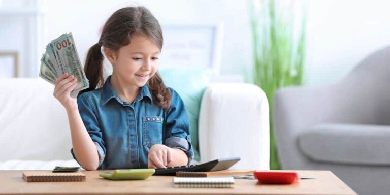 young girl with hand of money and smiling, using calculator at desk