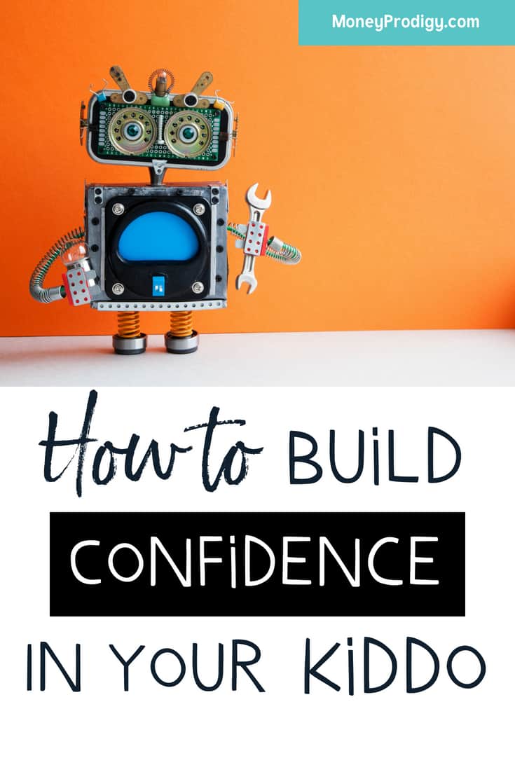 robot standing on white desk, orange background, text overlay "how to build confidence in your kid"