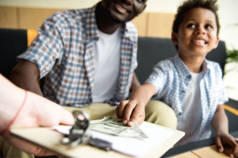 boy tipping waitress at restaurant with father