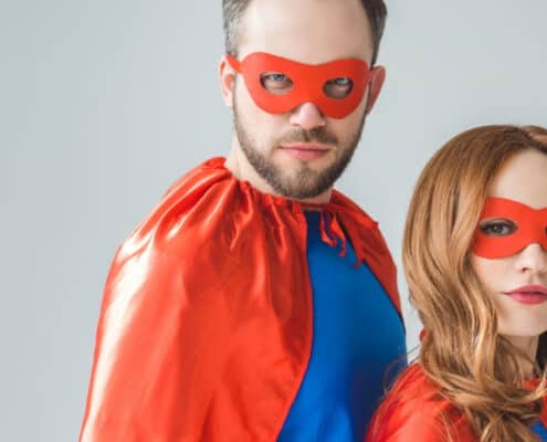 mother and father in superman outfits, on grey background
