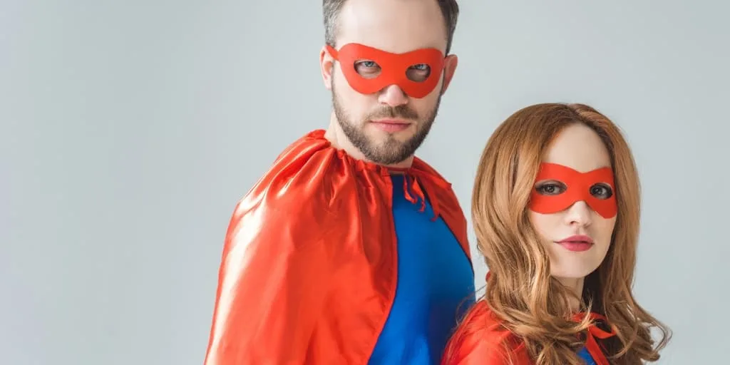 mother and father in superman outfits, on grey background