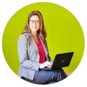 image of author Amanda L. Grossman on laptop, wearing glasses and business suit