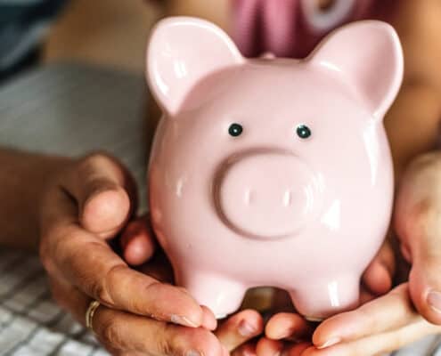 family holding a piggy bank and talking about compound interest for kids