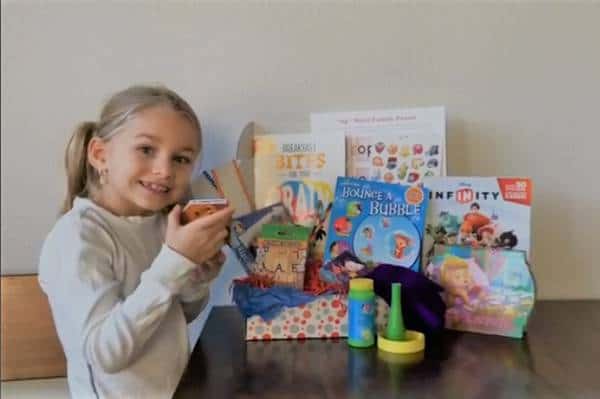 learning crates kid subscription box review with a young girl, next to bubbles and books