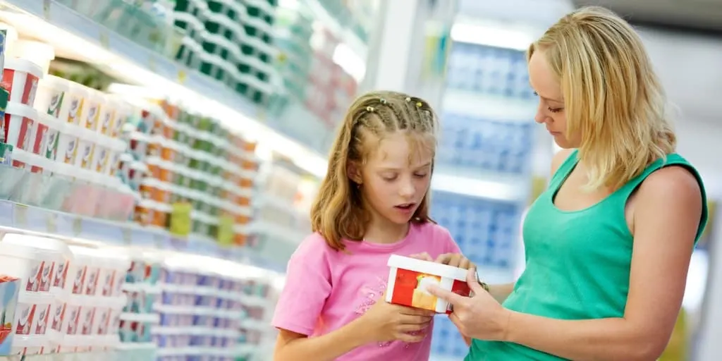 Daughter and mother in store aisle, daughter asking mother to buy her something