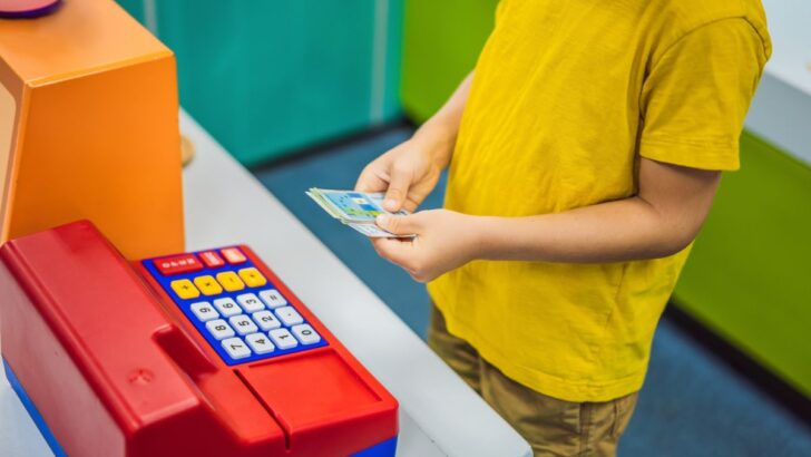 boy playing with pretend cash register