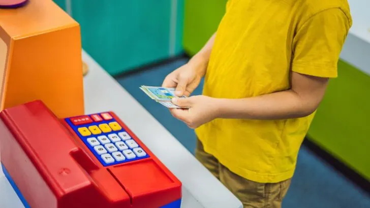 boy playing with pretend cash register