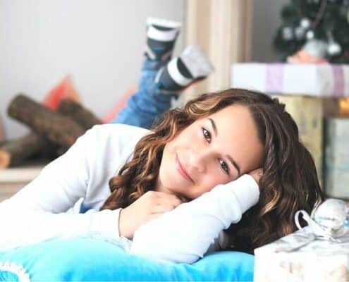 teenage girl laying on floor in front of gifts - amazon gifts for teenage girl