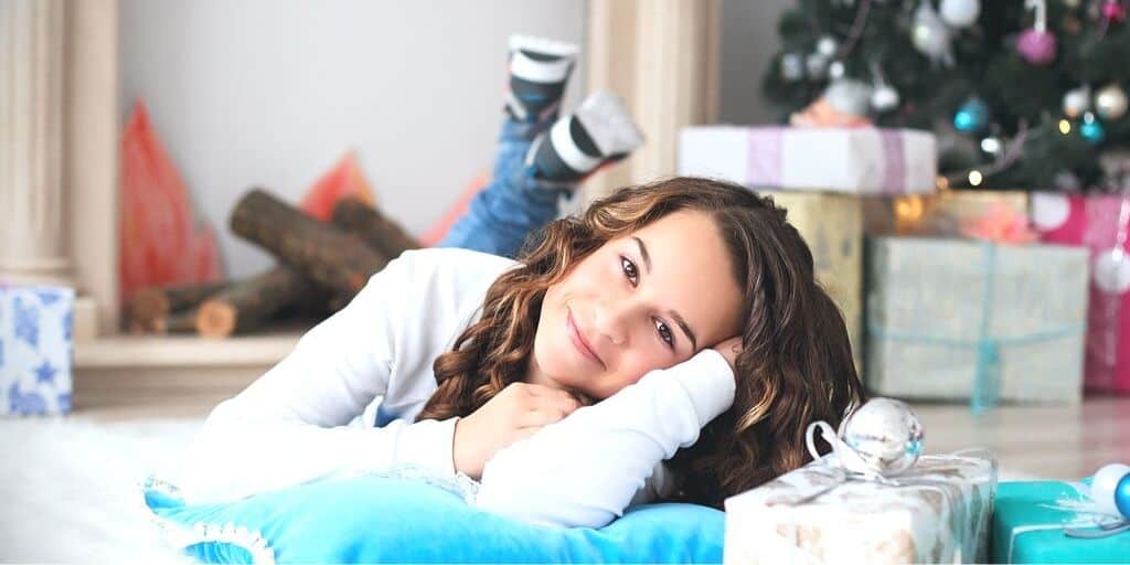 teenage girl laying on floor in front of gifts - amazon gifts for teenage girl