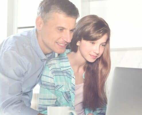 dad helping teenage daughter with online stock market game for kids