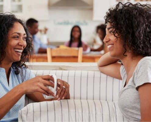 mother and daughter on couch, talking about first paycheck - teenager