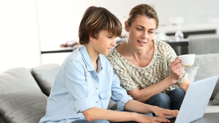 mother with tween boy buying stocks on a laptop