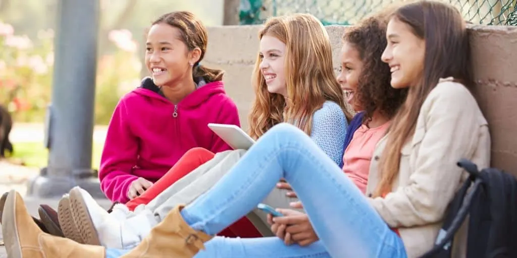 group of girl teenagers sitting and talking, maybe about money should i have saved by 18