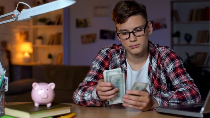 18 year old teen guy counting money at desk