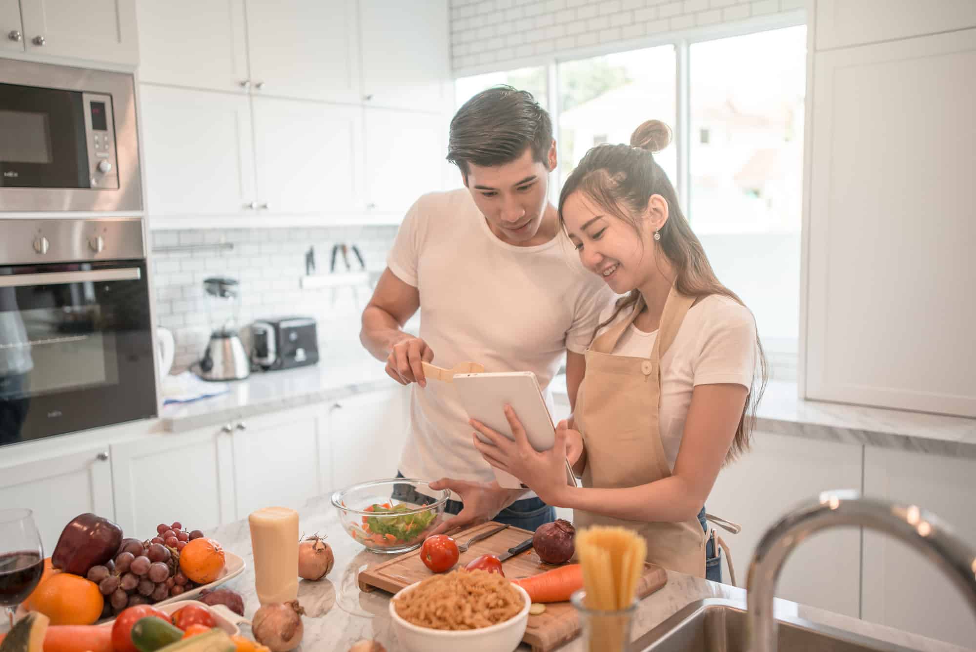 teen couple cooking a dish together - things for teenage couples to do at home