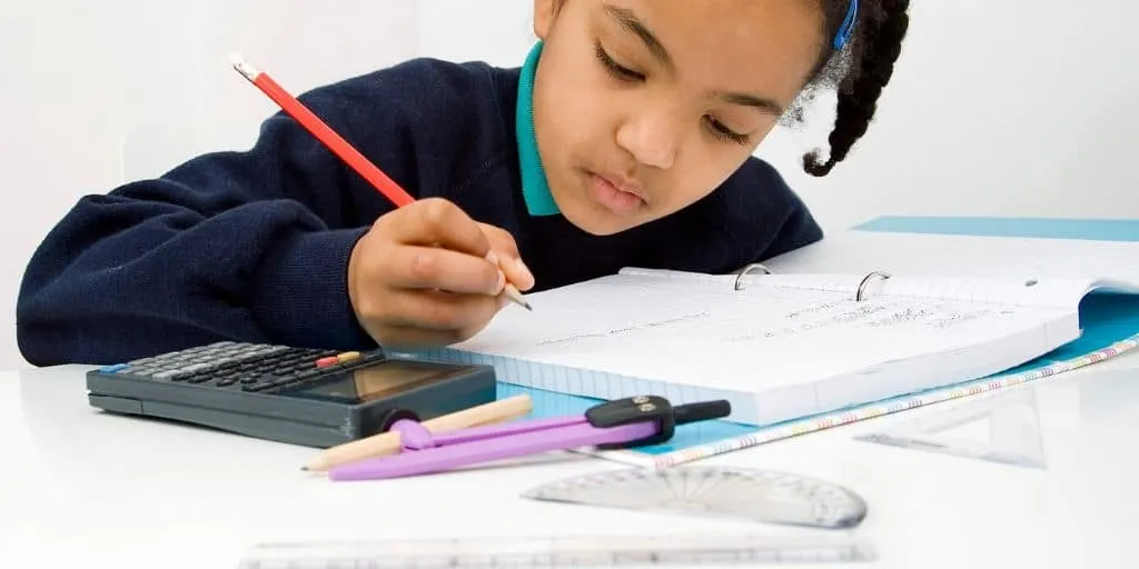 young child working on a stock market worksheet pdf at a desk, with calculator and pencil