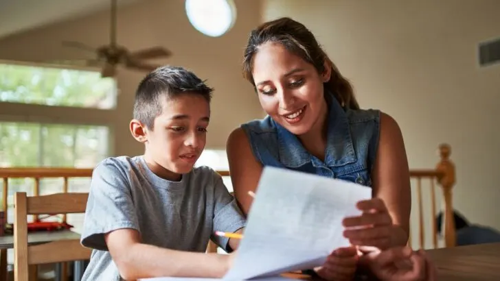 mother helping son with stock market worksheet