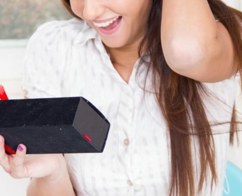 teenage girl opening money gift in a box, creatively given to her