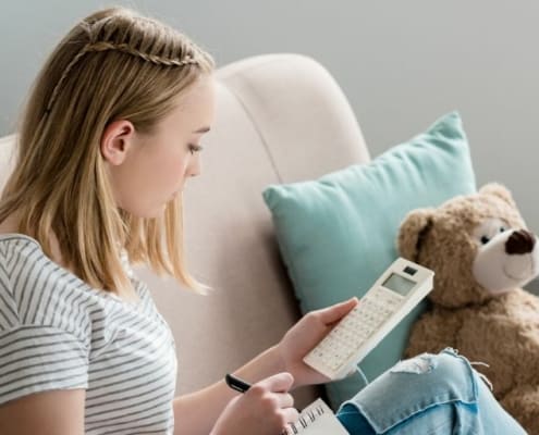 teen student sitting on couch working on goal setting worksheets for teens pdf