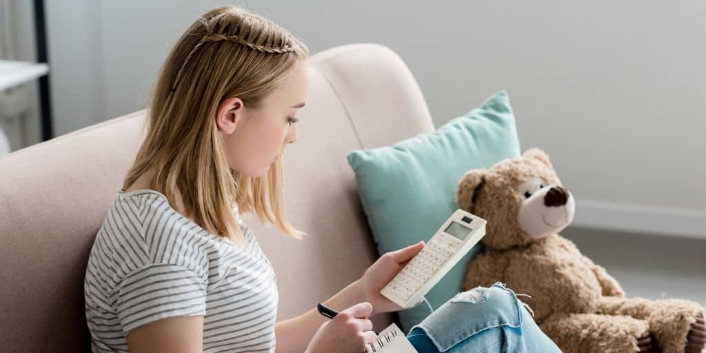 teen student sitting on couch working on goal setting worksheets for teens pdf