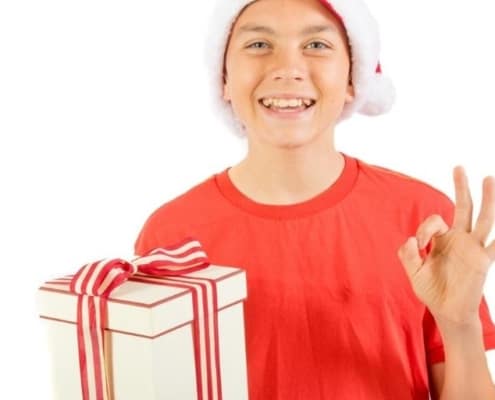 tween boy wearing Santa hat with cheap stocking filler for boy gift