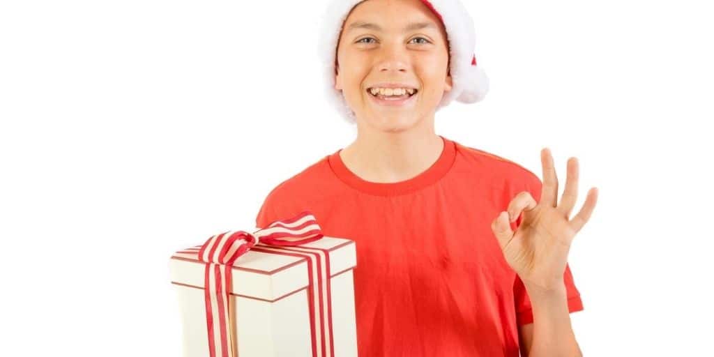 tween boy wearing Santa hat with cheap stocking filler for boy gift