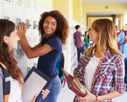 group of teen girls at locker in high school, discussing goals for high school seniors