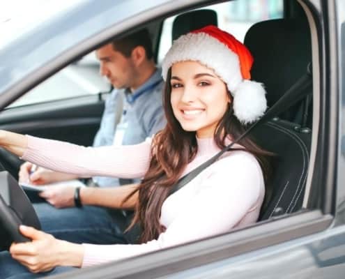teen girl driver with Santa hat on, trying out stocking stuffers for teenagers she got Christmas morning