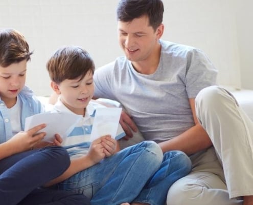 father with two sons and their cash envelopes for kids