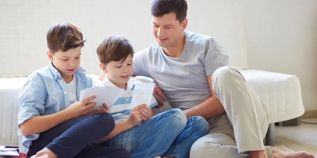 father with two sons and their cash envelopes for kids