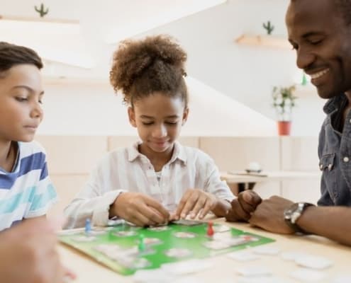 family playing a game about credit with kids to explain credit to a child