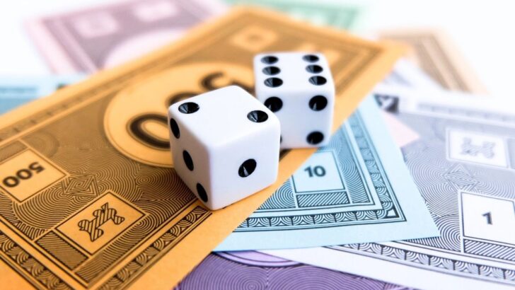 pretend game money on white table with dice