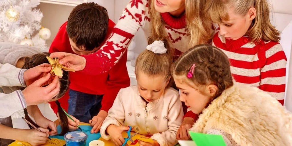 teacher working with students, handing on a stocking stuffer gift - classroom of students