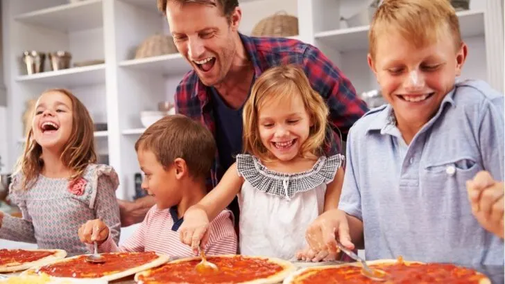 dad with four kids, having a blast making homemade pizzas together