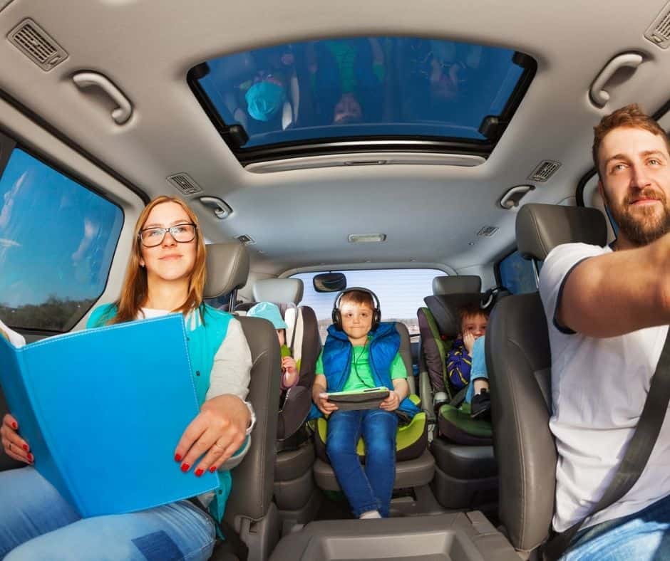 family of five (2 parents, 3 kids) that picked kids up from school and are doing homework in the car