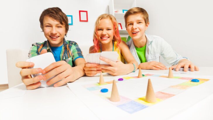 three tweens playing a budget board game together