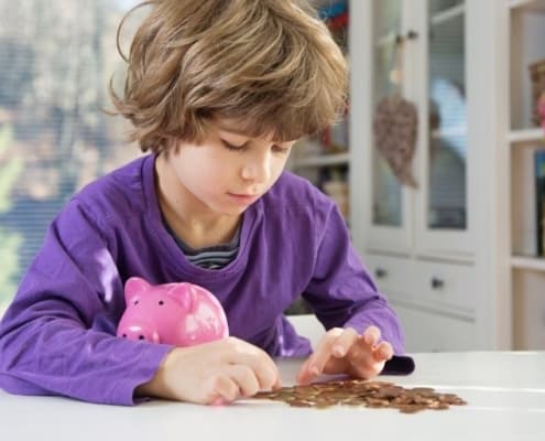 kid boy counting money with piggy bank, teaching budget for kids