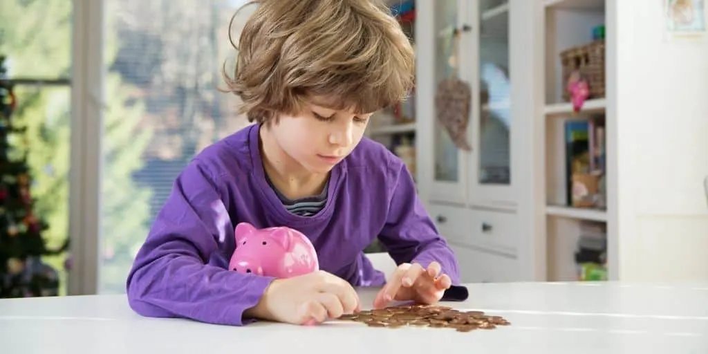 kid boy counting money with piggy bank, teaching budget for kids