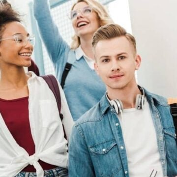 group of high school students walking down stairs to career exploration class, smiling