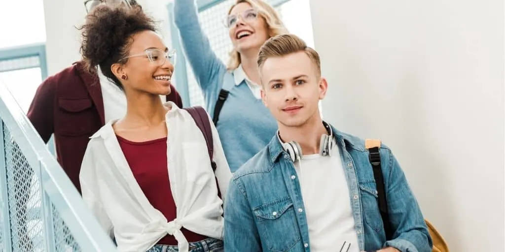 group of high school students walking down stairs to career exploration class, smiling