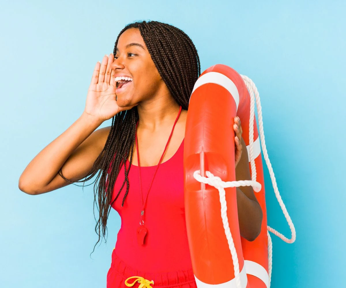 teen girl calling out in lifeguard uniform with lifesaver