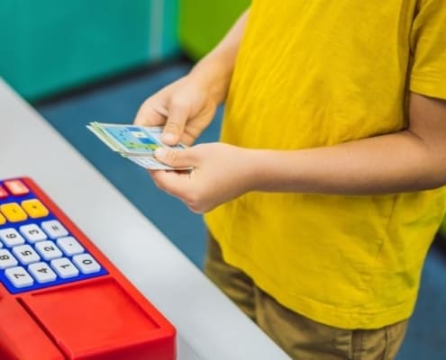 boy kid playing with printable play money for kids and play cash register
