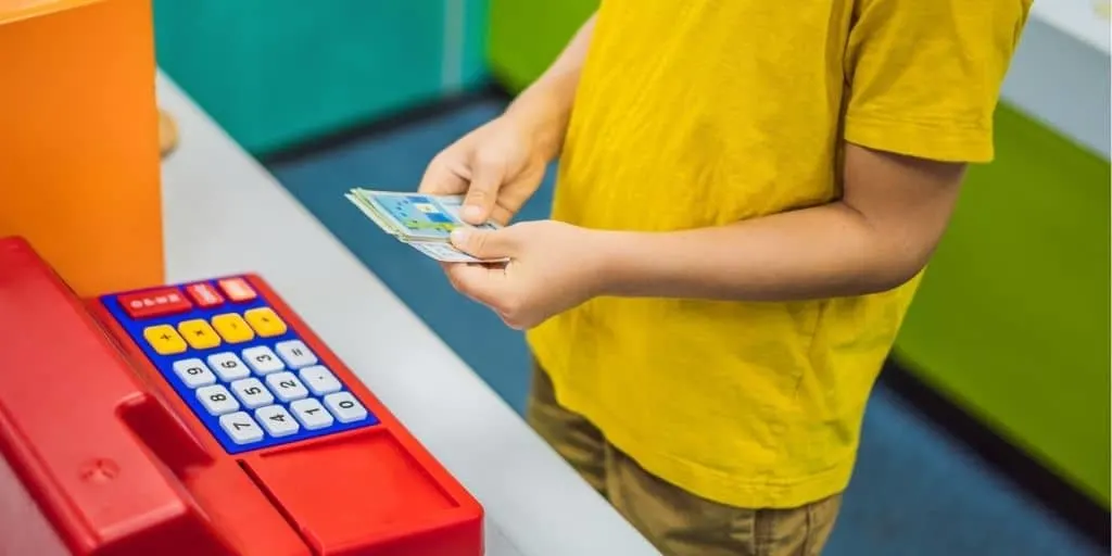 boy kid playing with printable play money for kids and play cash register