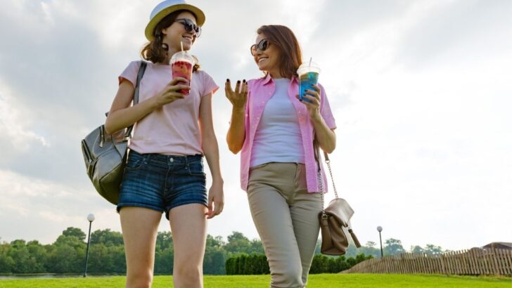 mom with teenage daughter outside, both have fun drinks