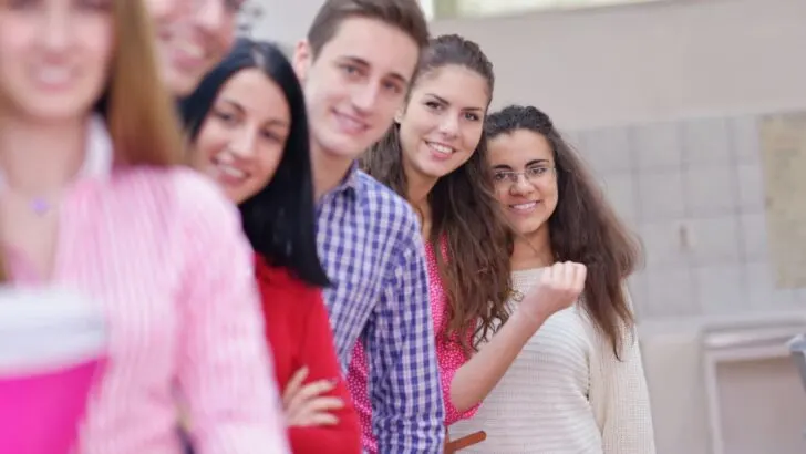 line of smiling teen students in high school on Valentine's Day